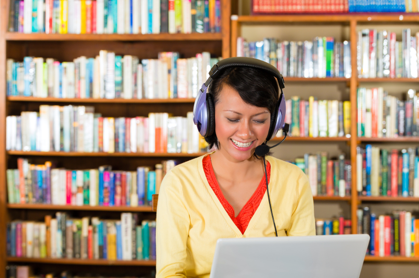 Young Girl in library with laptop and headphones